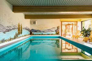 - une piscine dans une maison ornée d'une peinture murale dans l'établissement Landhotel GrünWies -Bonsai-Wellness Garni, à Lohberg