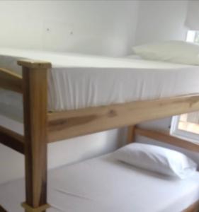 een houten stapelbed in een kamer met een raam bij HospedajeLR in Barrancabermeja