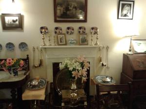 a living room with a fireplace with a vase of flowers at Ben View Guesthouse in Clifden