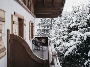 蓬高圣约翰欧博弗斯特霍夫酒店的一个带雪覆盖树木的门廊上的椅子