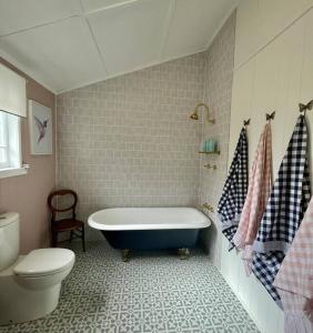 uma casa de banho com banheira e WC em Gorgeous Arthouse Queenslander In Ipswich em Bundamba