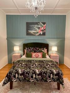 um quarto com uma cama grande e 2 mesas de cabeceira em Gorgeous Arthouse Queenslander In Ipswich em Bundamba