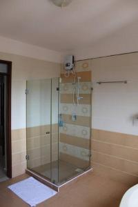 una doccia con porta in vetro in bagno di Ocean View Apartment D7 a Mombasa