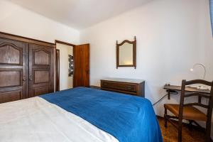 a bedroom with a bed and a desk and a mirror at Cabo de Sagres -2 bedroom apartment in Sagres