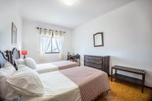 a bedroom with two beds and a dresser at Cabo de Sagres -2 bedroom apartment in Sagres