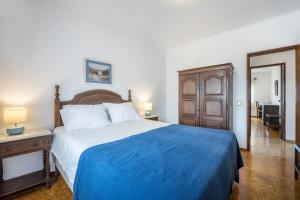 a bedroom with a large bed with a blue blanket at Cabo de Sagres -2 bedroom apartment in Sagres