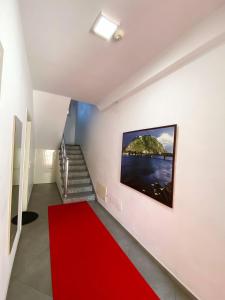 a staircase with a red carpet and a red rug at Hotel Shkodra L in Shkodër