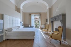 een slaapkamer met een groot bed en een open haard bij Hotel Ariele in Florence