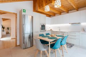 a kitchen with a wooden table and blue chairs at Apartamento Férias (Apartamento Norte) in Costa Nova