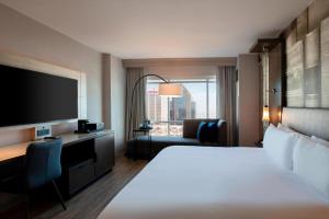 una camera d'albergo con letto, scrivania e TV di Louisville Marriott Downtown a Louisville