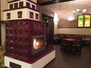 una chimenea en el comedor de un restaurante en Penzion Fryštátská Chalupa, en Karviná