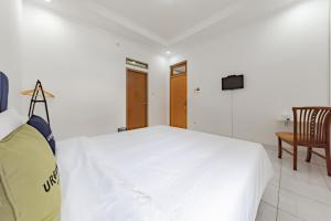 1 dormitorio blanco con 1 cama y TV en RedDoorz Plus near Universitas Maranatha Bandung 2, en Bandung