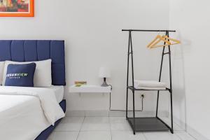 Un dormitorio con una cama azul y blanca y una silla en RedDoorz Plus near Universitas Maranatha Bandung 2, en Bandung