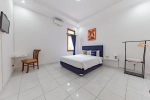 1 dormitorio con 1 cama y 1 silla en RedDoorz Plus near Universitas Maranatha Bandung 2, en Bandung