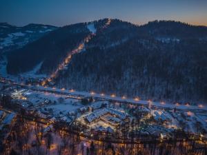 eine Luftansicht einer Stadt im Schnee in der Nacht in der Unterkunft Szczawnica Park Resort & Spa in Szczawnica