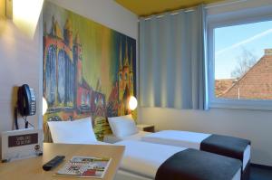 um quarto de hotel com duas camas e uma janela em B&B HOTEL Erfurt-Hbf em Erfurt