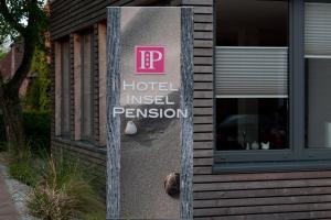 un panneau sur le côté d'un hôtel a invoqué la permission dans l'établissement Hotel Insel Pension, à Niebüll