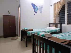 PRAKRITI HOMESTAY Fortkochi Air Conditioned Rooms tesisinde bir odada yatak veya yataklar