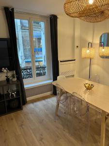 una sala da pranzo con tavolo, sedie e finestra di NOTRE DAME - STYLISH APARTMENT a Parigi