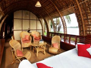 una camera con un letto, sedie e un tavolo di Marvel Cruise a Alleppey