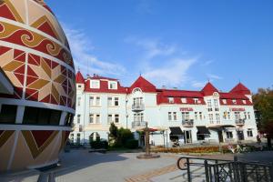 un grand bâtiment blanc avec des toits rouges dans l'établissement Pysanka Hotel, à Kolomya