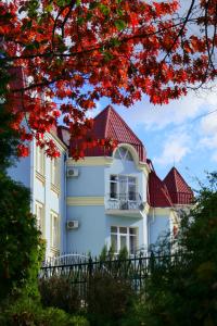 une grande maison blanche avec un toit rouge dans l'établissement Pysanka Hotel, à Kolomya