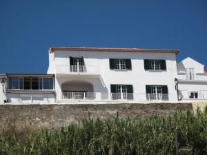 una casa blanca con ventanas negras en la pared en Manas Coliving, en Sines