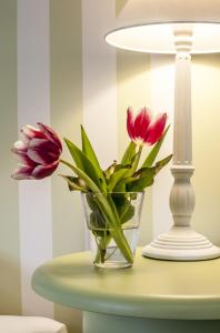 a vase of flowers on a table next to a lamp at Hotel & Restaurant Sonne in Kirchzarten