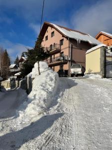 eine schneebedeckte Straße vor einem Haus in der Unterkunft Pensiunea Joe Paltinis in Păltiniş