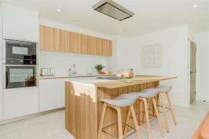 cocina con encimera de madera y taburetes en 7 Cliff Edge, en Newquay