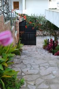 una pasarela de piedra con flores rojas en un edificio en Davide Rooms, en Sarandë