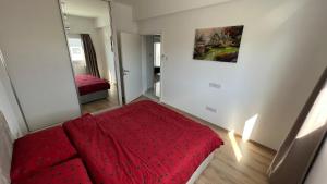 1 dormitorio con cama roja y espejo en Tetris Apartment Spacious Comfortable, en Lefkosa Turk