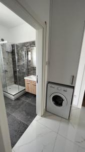 y baño con lavadora y ducha. en Tetris Apartment Spacious Comfortable, en Lefkosa Turk