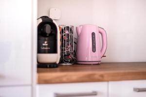 un apparecchio rosa seduto sopra un bancone della cucina di Marywilska apartment a Varsavia