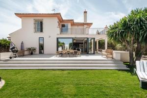 Cette grande maison blanche dispose d'une terrasse et d'une pelouse. dans l'établissement Villa Triana4, à Valencina de la Concepción