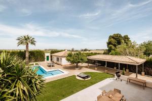 Elle offre une vue sur une arrière-cour dotée d'une piscine et d'une maison. dans l'établissement Villa Triana4, à Valencina de la Concepción