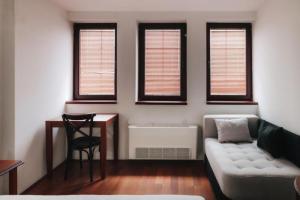 a living room with a couch and a table and windows at Hotel Castrum in Skopje