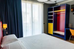 een slaapkamer met een bed en een groot raam bij K MODERN HOTEL in Peschiera del Garda