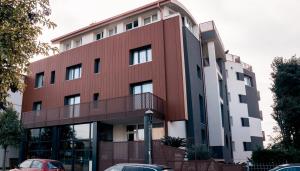 een rood gebouw met auto's ervoor geparkeerd bij K MODERN HOTEL in Peschiera del Garda