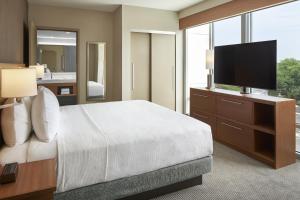 une chambre d'hôtel avec un lit et une télévision dans l'établissement Hyatt Place Evansville, à Evansville