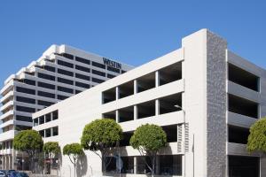 ein weißes Bürogebäude mit Bäumen davor in der Unterkunft The Westin Los Angeles Airport in Los Angeles