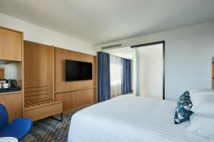 een hotelkamer met een bed en een flatscreen-tv bij Courtyard by Marriott Exeter Sandy Park in Exeter