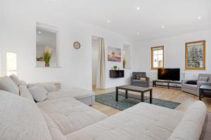 a white living room with a couch and a tv at Apartmán Ela in Horní Blatná