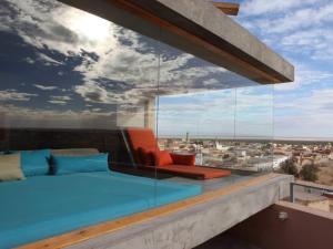 einen Balkon mit einem Sofa und Stadtblick in der Unterkunft Hotel Dar Hi in Nefta