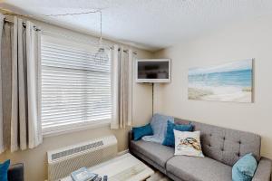 sala de estar con sofá y ventana en The Oceanfront Litchfield Inn 251, en Pawleys Island