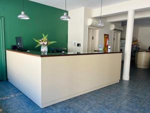 eine Lobby mit einer Theke mit einer Blumenvase darauf in der Unterkunft Hotel Lobato in Paysandú