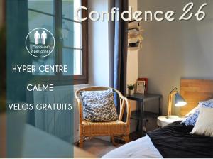 エクスレバンにあるAppartements CONFIDENCE hyper centre calme - SEJOURAIXLESBAINSのベッドルーム1室(ベッド1台、椅子、テーブル付)