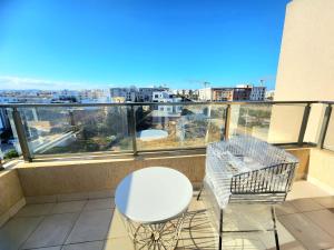 einen weißen Tisch und Stühle auf einem Balkon mit Aussicht in der Unterkunft Accueillant S+1 jardin de carthage in Tunis