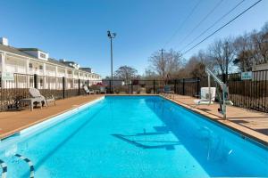 - une piscine d'eau bleue en face d'un bâtiment dans l'établissement Baymont by Wyndham Prattville - Montgomery, à Prattville