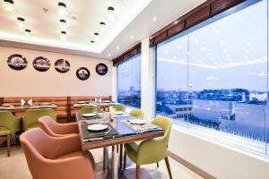 un restaurante con mesa, sillas y una gran ventana en SureStay by Best Western Heritage Walk, en Amritsar